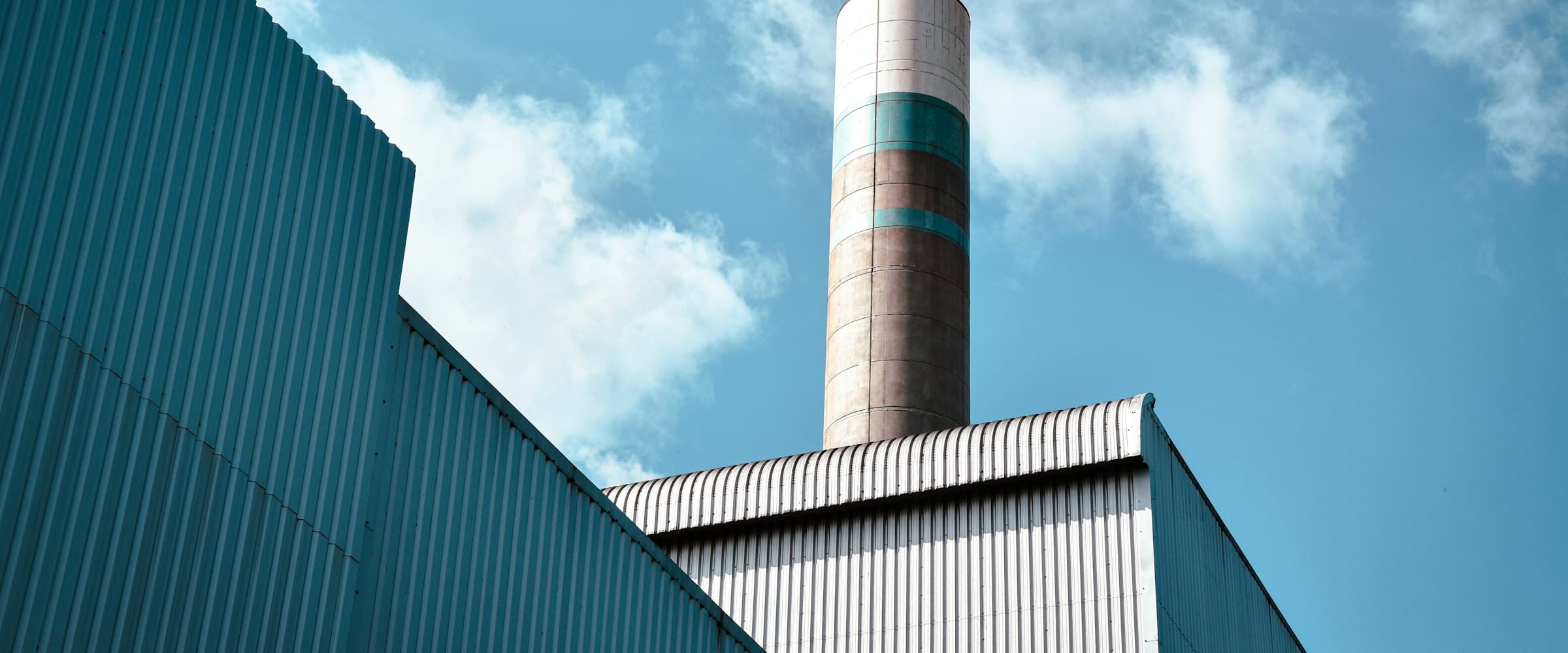 Industrial building with a tall smokestack against the sky